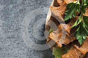 Spicy raw meatballs with lettuce and parsley on rustic table