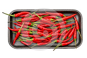 Spicy red hot peppers on black tray isolated