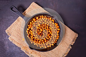Spicy roasted chickpeas in a black metal pan. Healthy and vegetarian food photo