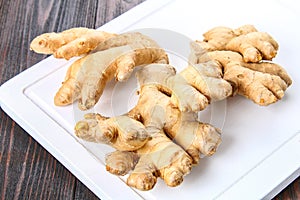 Spicy root of ginger on a wooden table.