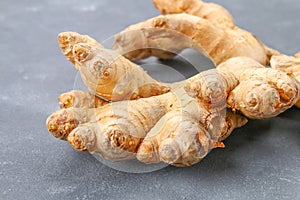 Spicy root of ginger on a wooden table.