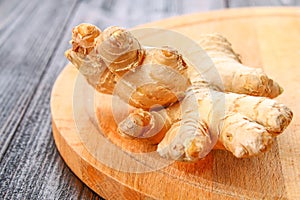 Spicy root of ginger on a wooden table.