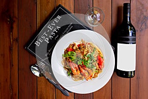 Spicy seafood spaghetti pasta or Spaghetti tom yum with a bottle of wine, a fusion of Italian food style and the best food in