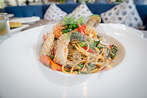 Spicy Seafood Spaghetti stir fried Pad Cha rolled in the fork on white dish of luxury restaurant