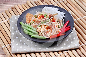 Spicy and sour mixed vegetable salad with rice noodle served .