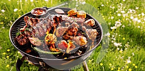 Spicy spare ribs and chicken grilling on a BBQ photo