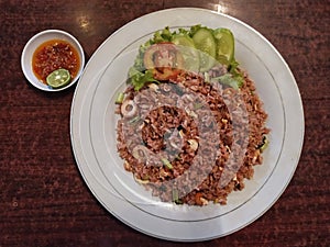 Spicy squid fried rice with cucumber slices and chili sauce photo
