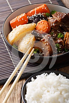 Spicy stewed ribs with vegetables, sesame and rice garnish close