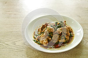 spicy stir-fried chili chicken meat and gizzard with basil on plate