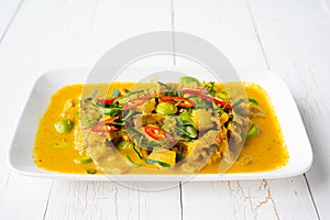 Spicy stir fried pork with Cluster Bean (Bitter Bean or stink beans) popular southern Thai food on wood background