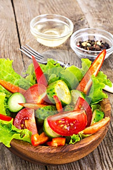 Spicy Summer Salad from Red Hot Chilly Pepper, Tomato and Cucumber on Wooden Plate