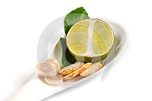 Spicy Thai food ingredients lime,ginger, kaffir ,lemongrass in spoon isolated on white