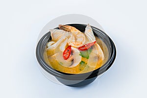 Spicy Tom Yam soup with seafood served in plastic delivery bowl, isolated on gray background