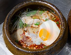 Spicy tom yum noodle in the clay bowl