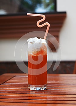 Spicy tomato juice with carrot and cream in a tall glass