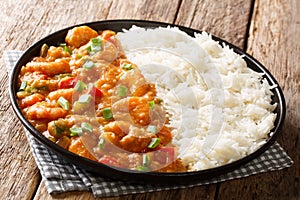 Spicy traditional shrimp Etouffee with celery, onion and pepper with sauce served with rice closeup in a plate. horizontal