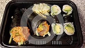 Spicy tuna and handroll and avocado sushi in container