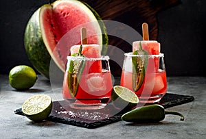 Spicy watermelon popsicle margarita cocktail with jalapeno and lime. Mexican alcoholic drink for Cinco de mayo party.