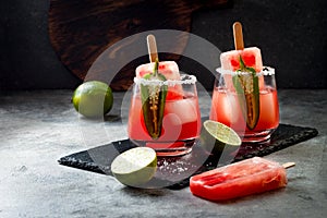 Spicy watermelon popsicle margarita cocktail with jalapeno and lime. Mexican alcoholic drink for Cinco de mayo party.