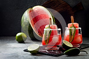 Spicy watermelon popsicle margarita cocktail with jalapeno and lime. Mexican alcoholic drink for Cinco de mayo party.