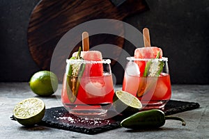 Spicy watermelon popsicle margarita cocktail with jalapeno and lime. Mexican alcoholic drink for Cinco de mayo party.