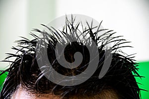 Spike hairstyle of a young man. Closeup of a spiky hairstyle of student using hard hair gel