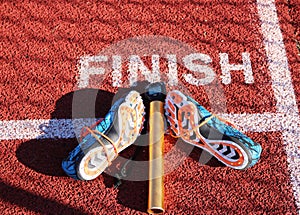 Spikes, baton and stop watch at the finish line on a track