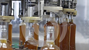 Spill of alcoholic beverages in glass bottles at the plant. Conveyor belt with glass bottles. Spillage of alcoholic