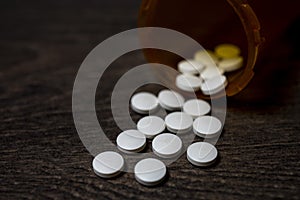 Spilled bottle with medicine pill tablets close up