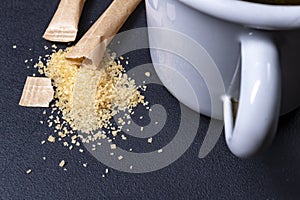 Spilled cane sugar from a paper bag. Sweetening tea with sugar