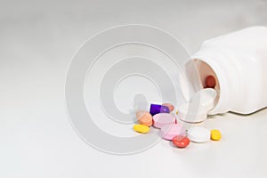 Spilled Capsules from Prescription Bottle on white background.