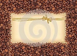 Spilled coffee beans frame over burlap textile with greeting