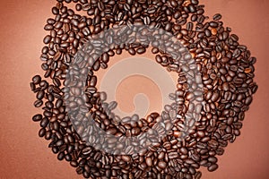 Spilled coffee beans. In the middle is a place in the shape of a circle for text