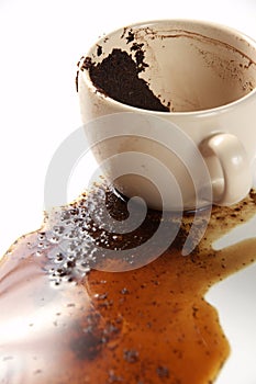 Spilled coffee cup with coffee grounds.