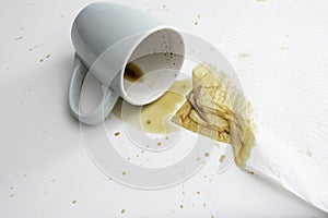 Spilled cup of coffee with apiece of absorbent paper towel photo