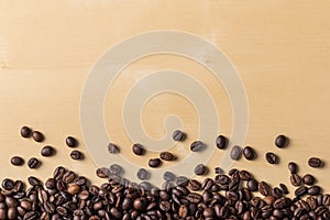 Spilled fresh coffee beans on blonde wooden table