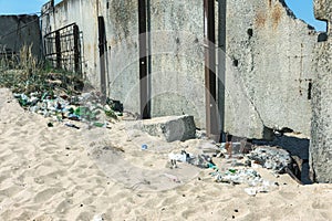 Spilled garbage on beach of big city. Empty used dirty plastic bottles. Dirty sea sandy shore Black Sea. Environmental pollution.