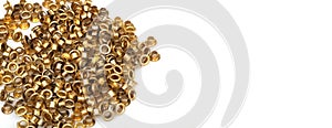 Spilled gold grommets isolated on white background