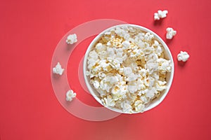 Spilled popcorn on a red background  cinema  movies and entertainment concept