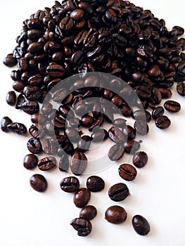 Coffee beans spilling in a while background