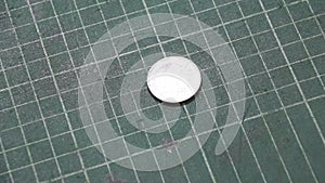 Spin of 5 baht of Thai money on the green cutting plate and stop in reverse of a coin.