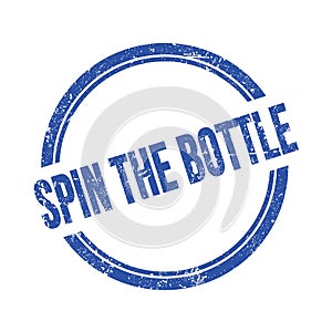 SPIN THE BOTTLE text written on blue grungy round stamp