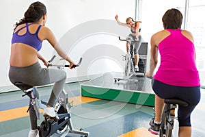 Spin class working out with motivational instructor