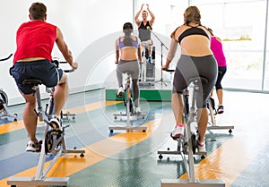 Spin class working out with motivational instructor