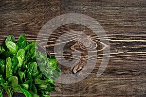 Spinach baby leaves on wooden background. Top view. Copy space