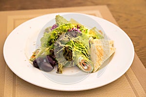Spinach crepes with salmon and salad mix