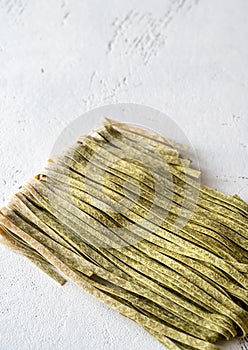Spinach fettuccine on wooden background