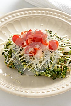 Spinach fritter topped with tomatoes and cheese