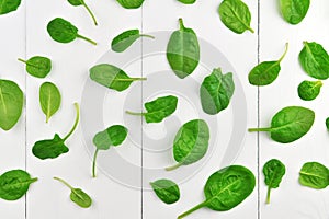 Spinach leaves pattern on white wooden table background. Healthy vegan food trend. Vegan lifestyle concept. Top view.