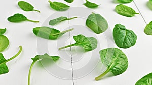 Spinach leaves on white wooden table background. Healthy vegan food trend. Vegan lifestyle concept